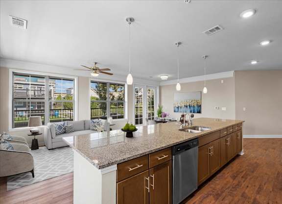 a kitchen with a large island and a living room in the background at The Dorset, Kansas City, 64112