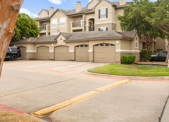 an empty parking lot with a large house in the background