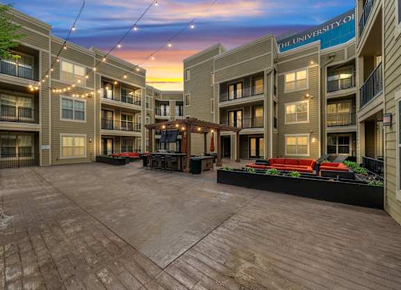 Outdoor common area at West 39th Street Apartments with lounge furniture, string lights, and backdrop  at West 39th Street Apartments, Kansas City, Missouri