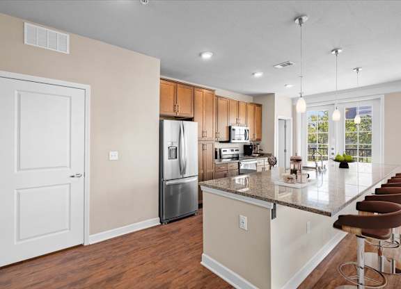 a kitchen with a large island and stainless steel appliances at The Dorset, Kansas City, 64112