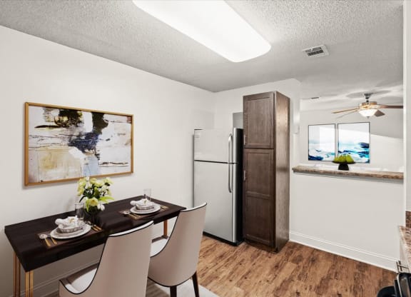 a dining room with a table and chairs and a refrigerator at Fiesta Square Apartments & Townhomes, Kansas, 66212