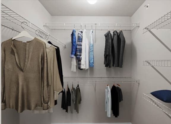 a walk in closet with a white closet and white shelves at The Clairborne Apartment Homes, Grand Prairie