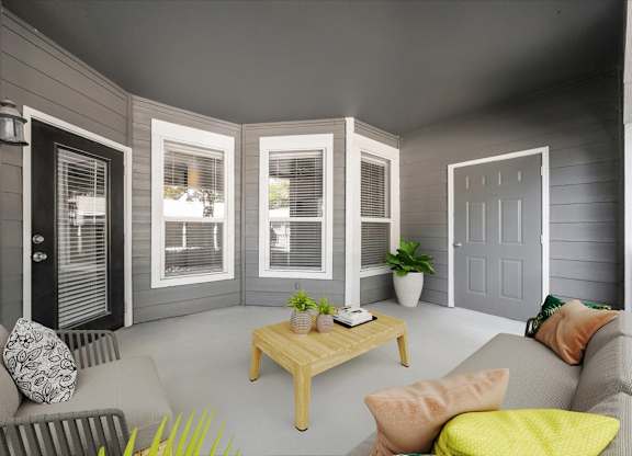 A living room with a grey couch, a wooden coffee table, and a grey wall. at Somerset Oaks Apartment Homes, Olathe
