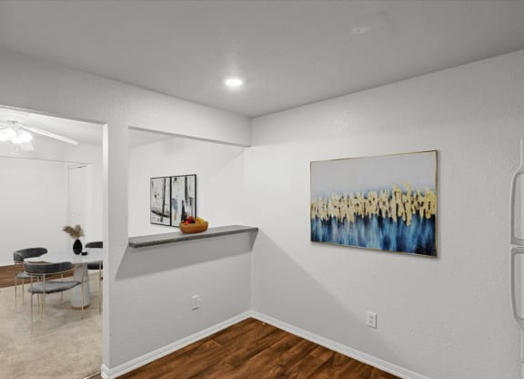 an empty room with a dining room table and a painting on the wallat Millcreek Woods Apartments, Olathe