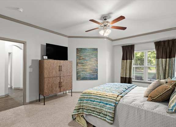 a bedroom with a bed and a ceiling fan at Stonepost Crossing Apartments, Overland Park, KS