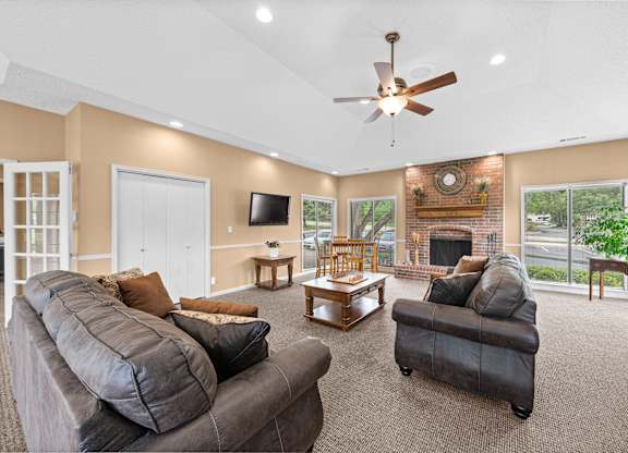 A living room with a grey couch and a fireplace.