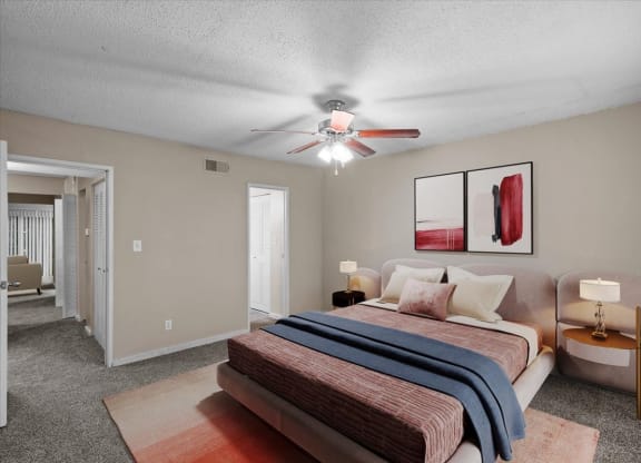 A bedroom with a ceiling fan and attached master bathroom.
