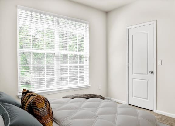 a bedroom with a bed and a large window