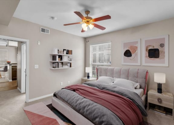 a bedroom with a bed and a ceiling fan at The Clairborne Apartment Homes, Grand Prairie, Texas