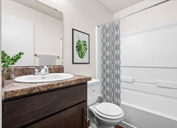 a bathroom with a sink toilet and shower at Fiesta Square Apartments & Townhomes, Overland Park, KS