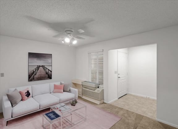 a living room with a white couch and a ceiling fanat Millcreek Woods Apartments, Olathe, 66061