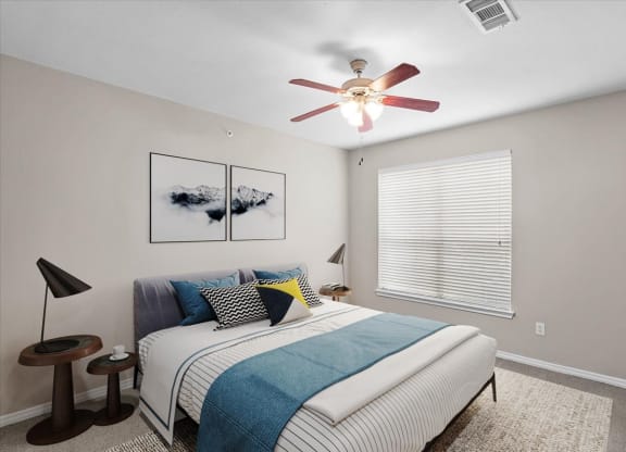 a bedroom with a bed and a ceiling fan at The Clairborne Apartment Homes, Grand Prairie, TX, 75050