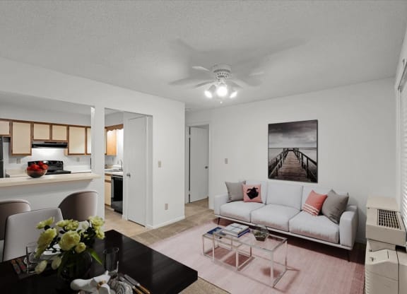 a living room and kitchen with a couch and a tableat Millcreek Woods Apartments, Olathe, KS, 66061