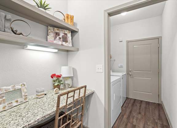 a dining room with a table and chairs and a laundry room in the background at Stonepost Crossing Apartments, Kansas, 66213