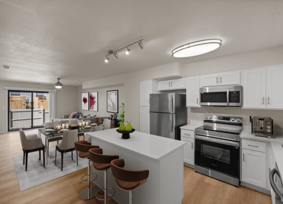 furnished kitchen and dining room with stainless steel appliances and a white island with stools