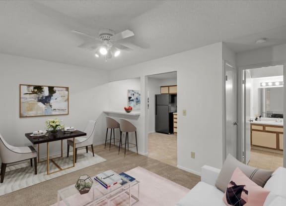 a living room and dining room with a table and a ceiling fanat Millcreek Woods Apartments, Olathe