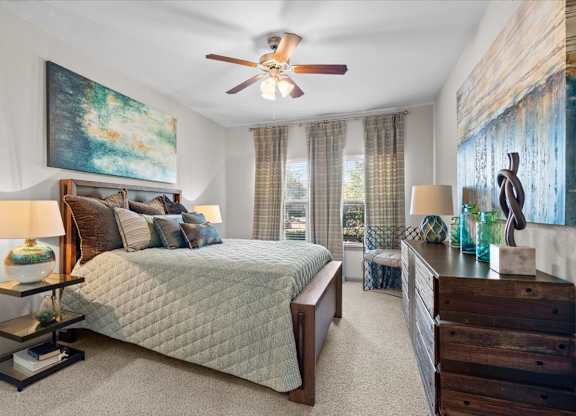 a bedroom with a bed and a ceiling fan at Stonepost Crossing Apartments, Kansas