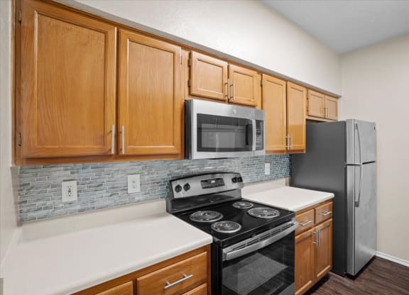 a kitchen with a stove refrigerator and microwave at Creekview Apartment Homes, Dallas, 75254