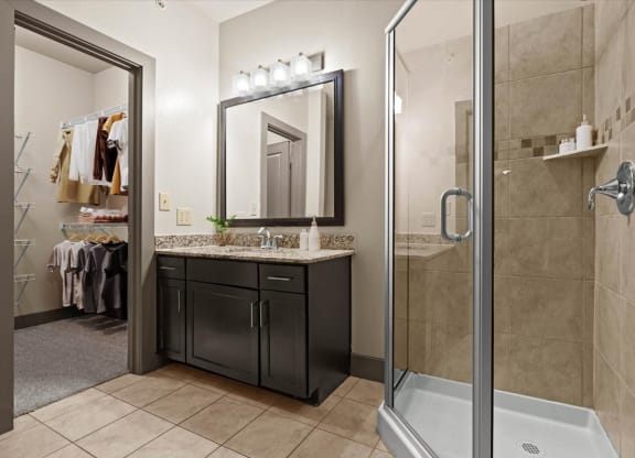 a bathroom with a shower stall sink and mirror
