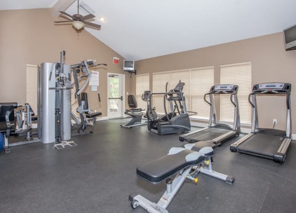 The fitness center with treadmills and weight machines at Preston Court Apartment Homes in Overland Park, Kansas.