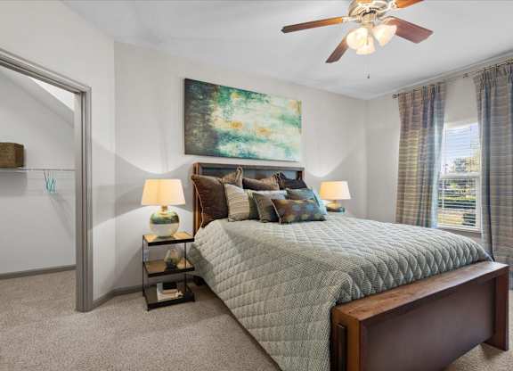 a bedroom with a bed and a ceiling fan at Stonepost Crossing Apartments, Overland Park, Kansas