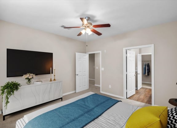 a bedroom with a bed and a ceiling fan at The Clairborne Apartment Homes, Texas