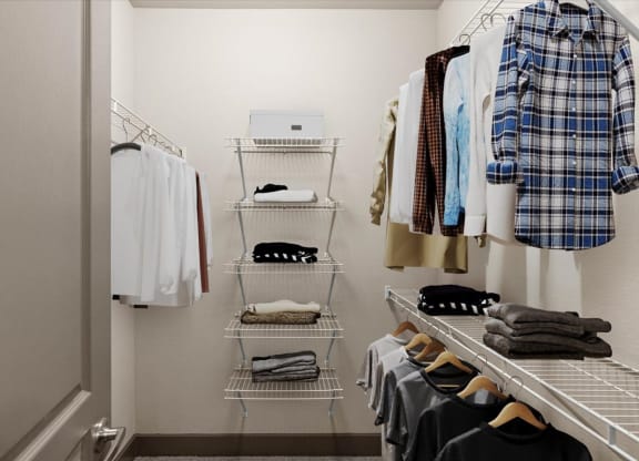 a walk in closet with white shelves and a white door