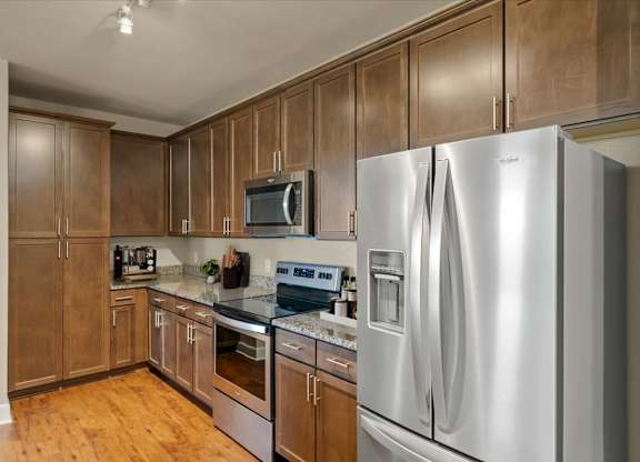 Kitchen with stainless steel refrigerator at The Residences at Bluhawk Apartments, Kansas, 66085