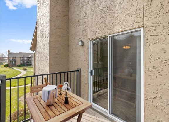 a patio with a table and a sliding glass door at Deerfield Apartments, Olathe, Kansas, 66062
