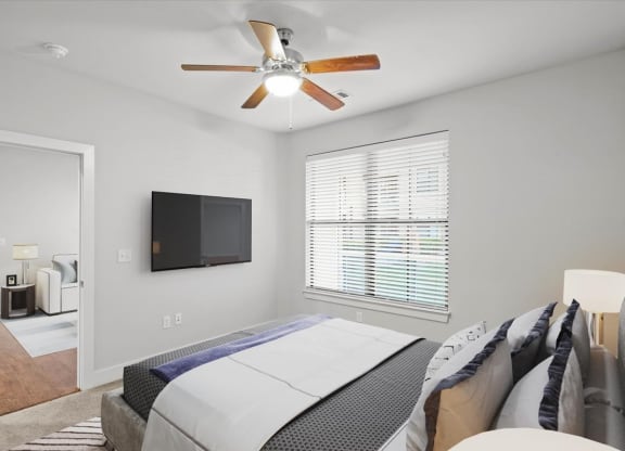 a bedroom with a large bed and a ceiling fan