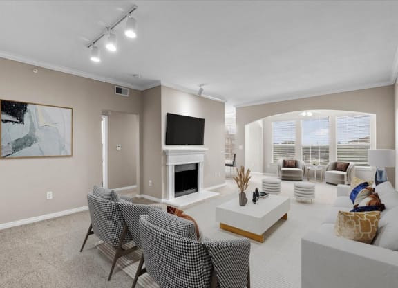 a living room with a fireplace and a large window at The Clairborne Apartment Homes, Grand Prairie, TX