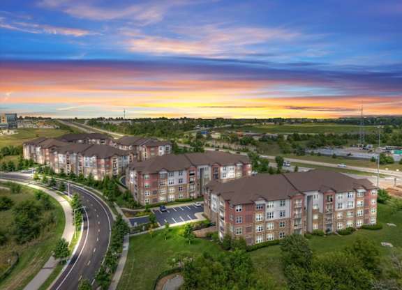 Aerial view of the property at sunset at The Residences at Bluhawk Apartments, Kansas, 66085