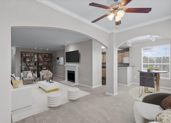 a living room with a fireplace and a ceiling fan at The Clairborne Apartment Homes, Texas