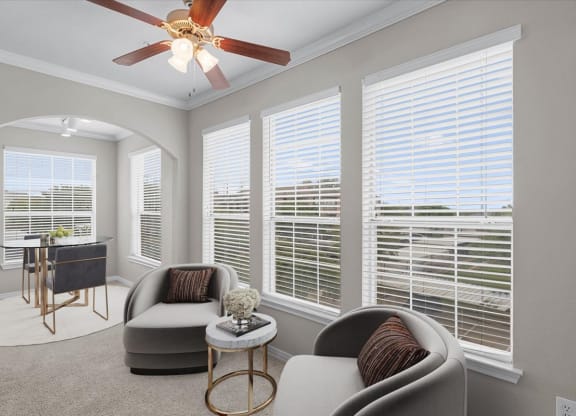 a living room with four windows and a ceiling fan at The Clairborne Apartment Homes, Grand Prairie, TX, 75050