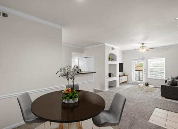 a dining area with a table and chairs and a living room in the background