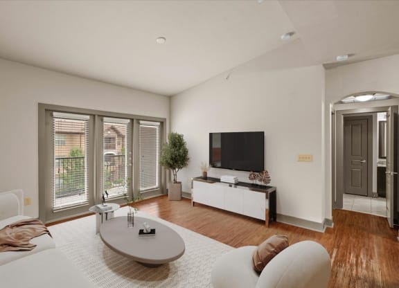 a living room with a white couch and a tv on the wall