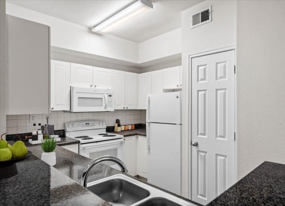 a kitchen with white cabinets and white appliances