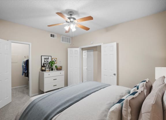a bedroom with a large bed and a ceiling fan at Creekview Apartment Homes, Dallas, 75254