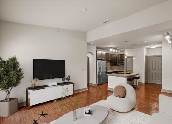 a living room with a white couch and a white coffee table in front of a flat screen