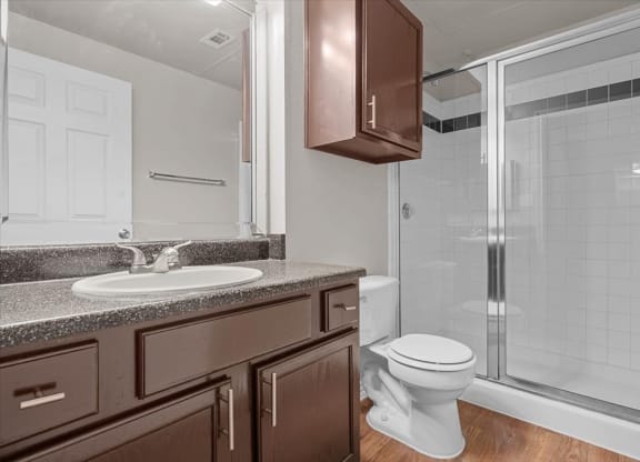 a bathroom with a toilet sink and shower at The Clairborne Apartment Homes, Grand Prairie