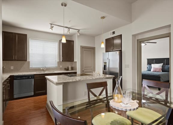 a kitchen and dining room with a bed in the background