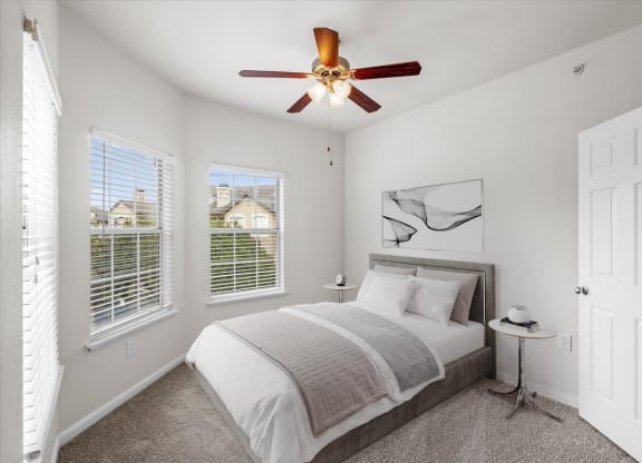a bedroom with a bed and three windows