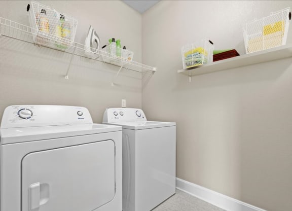 a white laundry room with two washes and a dryer
