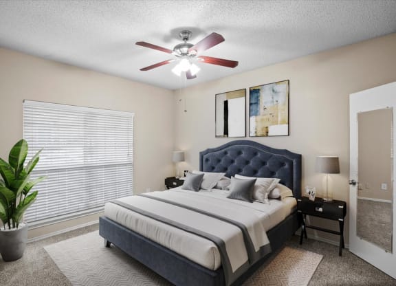 a bedroom with a large bed and a ceiling fan at Creekview Apartment Homes, Dallas, Texas