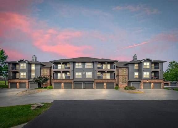A large apartment complex with a driveway in front.
