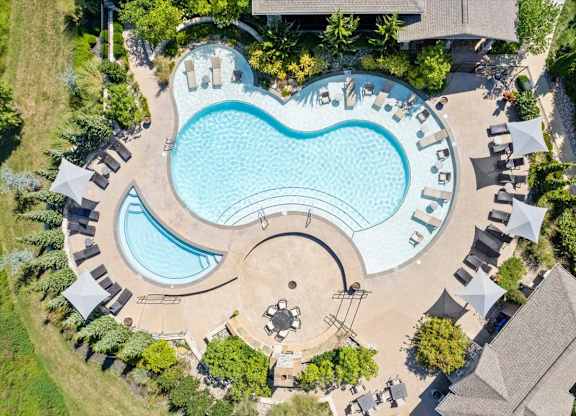 an aerial view of a swimming pool with lounge chairs and trees at Stonepost Crossing Apartments, Overland Park, 66213