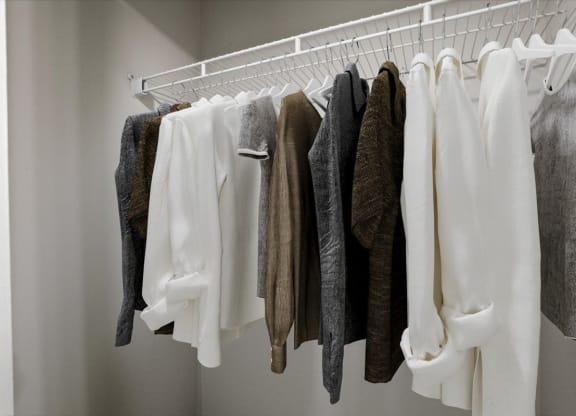 a wardrobe with white clothes and a white hanger at Creekview Apartment Homes, Texas
