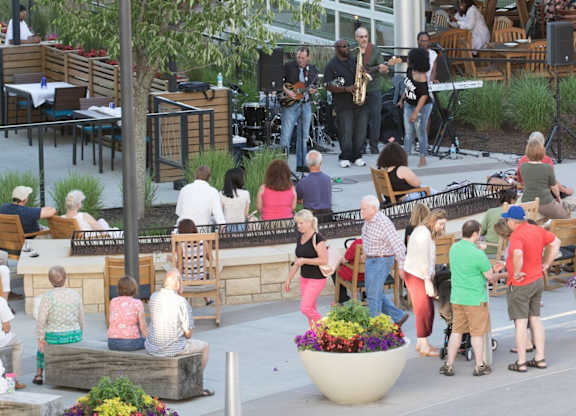 A group of people are gathered around a stage with a band performing. at Residences at Prairiefire Apartment Homes, Kansas, 66223