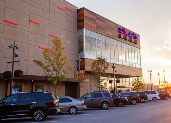 A Cineplex movie theater with cars parked in front at Residences at Prairiefire Apartment Homes, Overland Park, KS