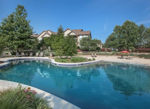 A beautiful, large lagoon pool with a sand beach entrance and lush landscaping.